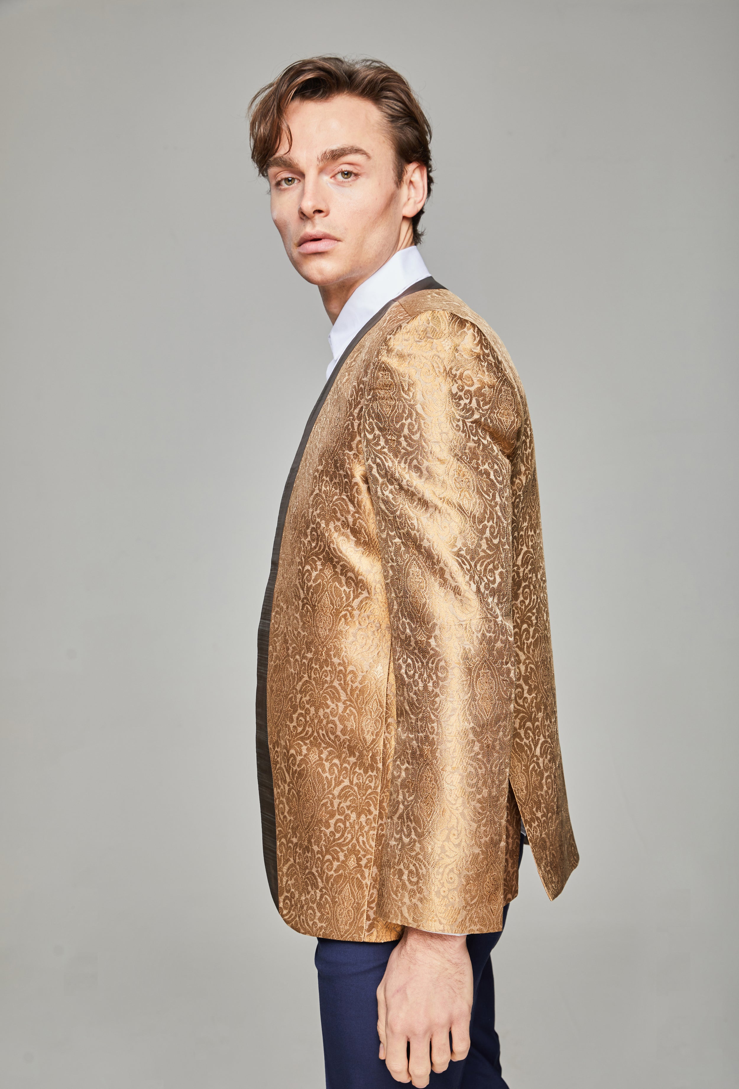 Side model shot wearing Firawn men's collarless, embroidered zari thread blazer with contrasting trim in Antique Gold